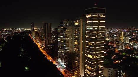 Skyscrapers-illuminated-along-Anacaona-avenue-in-Santo-Domingo-town-center-at-night,-Dominican-Republic