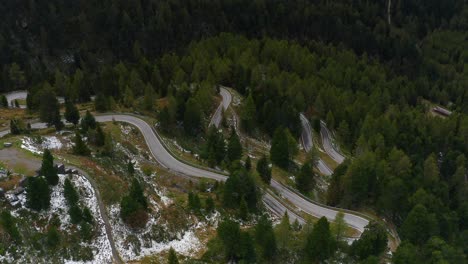Drone-flight-over-winding-forest-road,-beautiful-and-peaceful-surroundings-for-a-cinematic-experience