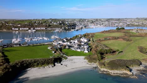 The-view-from-above-over-river-Bandon-and-sandy-beach-at-the-Dock,-over-rooftops-and-yachts-docked-in-marina,-towards-Kinsale-town-in-Ireland