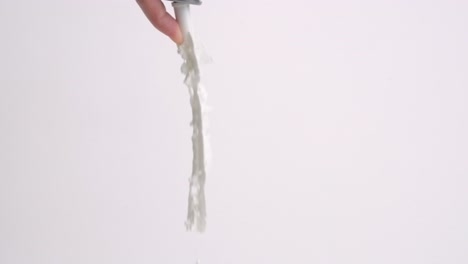 Finger-pressing-whipped-cream-can-tip-and-squirting-ribbon-of-fresh-fluffy-whip-creme-on-white-backdrop-in-slow-motion