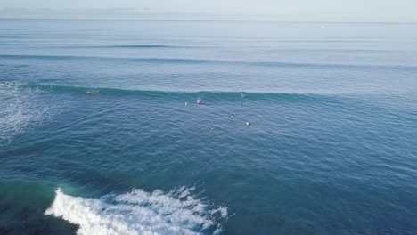 Surfers-at-dawn-break-catching-waves-at-Waikiki-Beach-Honolulu-Hawaii,-STATIC-AERIAL