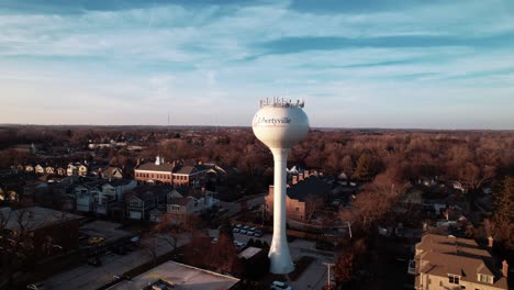 push-in-aerial-rising-aerial-of-watertank-tower-from-Libertyville,-Illinois,-USA-sunset-aerial-4k