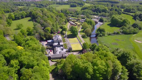 Aerial-view-over-pollock-house-famous-country-mansion-surrounded-by-vegetation-and-a-river-on-the-countryside-of-Glasgow