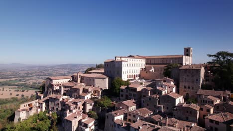 Aerial-view-of-medieval-town-Todi-on-top-of-a-green-hill,-Italy,-crane-shot