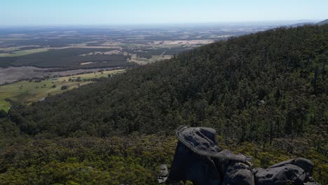 Aerial-reveal-of-giant-boulder-with-scenic-lookout-on-top-in-Australian-bushland