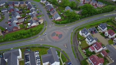 Aerial-video-of-a-roundabout-through-cars-circulate-surrounded-by-buildings-and-some-vegetation