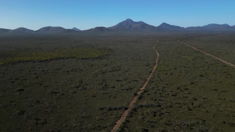 Aerial-push-in-of-mountain-tanges-and-red-dirt-road-in-Australian-outback