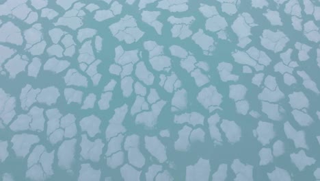 Aerial-view-tilting-over-ice-blocks,-revealing-the-Near-North-Side-of-Chicago,-USA