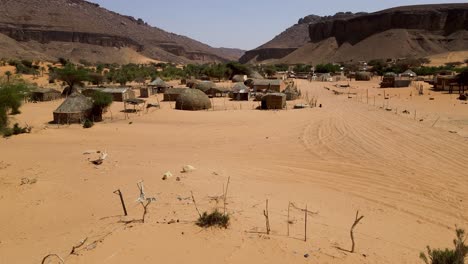 Rural-Thatch-Huts-in-Terjit-Oasis-in-Poverty-Stricken-Village,-Mauritania---Aerial-Drone-View