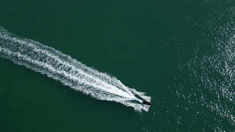 Top-down-aerial-tracking-shot-of-single-jet-ski-in-ocean
