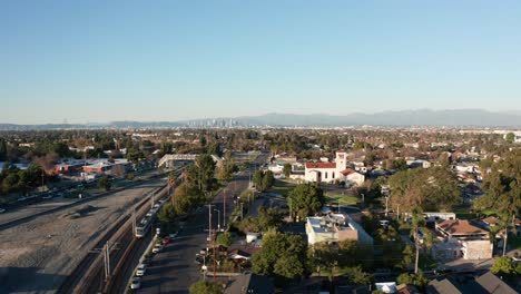 Aerial-fast-dolly-shot-from-the-LA-Metro-train-passing-by-to-the-Watts-Towers-with-downtown-Los-Angeles-in-the-background