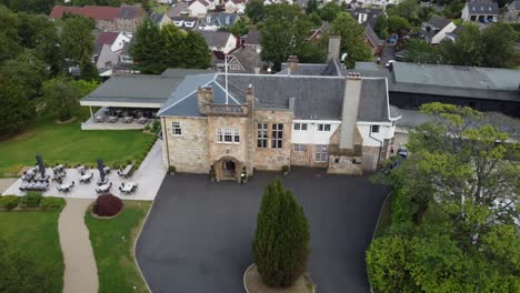 Fly-downwards-over-Dalmeny-Park,-a-luxurious-Scottish-country-mansion