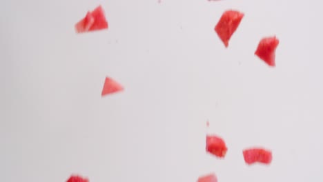 Rosafarbene,-Saftige-Wassermelonenwürfelstücke,-Die-In-Zeitlupe-Auf-Weißen-Hintergrund-Regnen