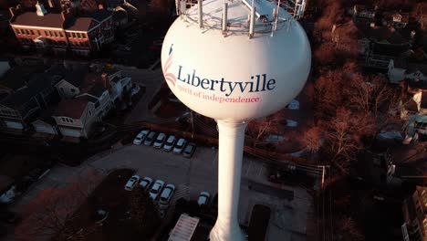 rising-aerial-of-watertank-tower-from-Libertyville,-Illinois,-USA-sunset-aerial-4k