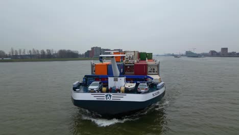 Aerial-Circle-Dolly-Um-Den-Vorderen-Bug-Des-Scaldis-Containerschiffs,-Das-An-Bewölkten-Tagen-In-Dordrecht-Entlang-Des-Flusses-Fährt