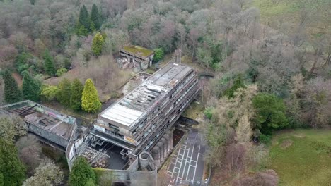 Aerial-fly-backwards-shot-of-winter-landscape-of-Saint-Peter's-Seminary-surrounded-by-trees