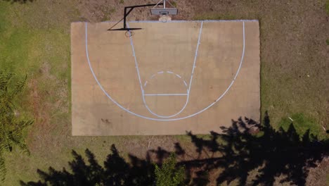 Top-down-aerial-view-of-rural-basketball-half-court-in-Australian-countryside