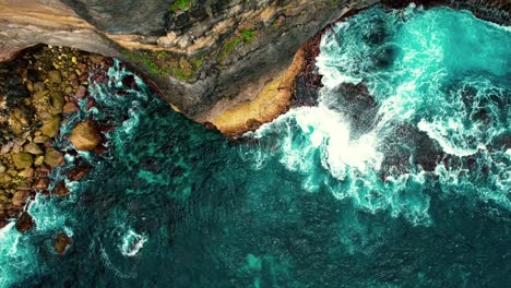 4k-Drone-Ascends-from-Waves-Crashing-against-Tall-Cliff-in-Bali,-Indonesia