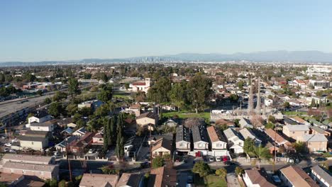 Wide-aerial-dolly-shot-of-the-Watts-Towers-with-the-LA-Metro-train-passing-by-in-Los-Angeles,-California