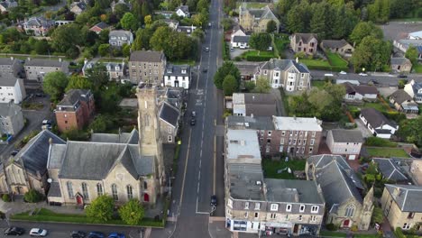 Fly-over-a-street-in-the-village-of-Helensburgh-with-some-cars-driving-on-it