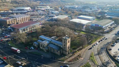 Cinematic-aerial-drone-footage-of-a-old-industrial-town-in-Yorkshire-England-showing-church-industrial-estate,-and-busy-town-with-traffic-and-roads