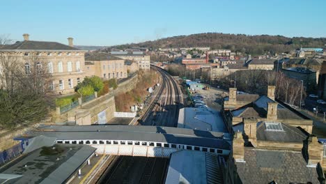 Cinematic-aerial-drone-footage-of-a-train-station-with-platform-and-carpark-UK