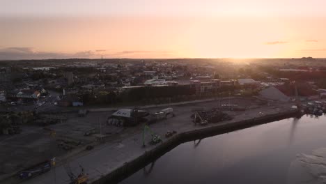Slow-drone-pull-back-from-Dundalk-harbor-while-the-sun-sets-over-the-city