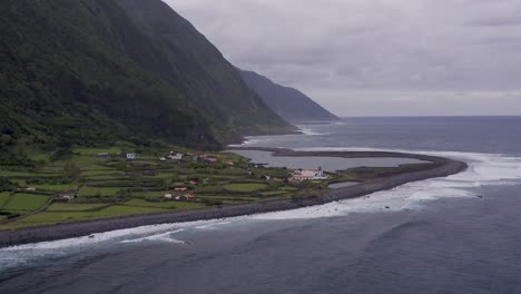 coastal-rural-village,-a-lagoon,-with-lush-green-cliffs-landscape,-Fajã-de-Santo-Cristo,-São-Jorge-island,-the-Azores,-Portugal