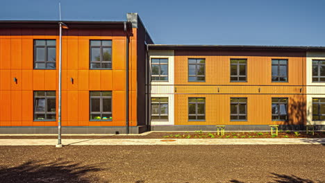 Zeitraffer-Eines-Orangefarbenen-Gebäudes-Mit-Symmetrischen-Fenstern,-Das-Die-Schatten-Der-Sich-Bewegenden-Vegetation-Zeigt