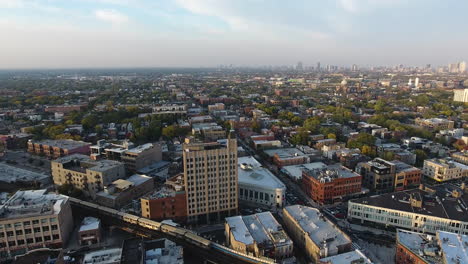 Aerial-View-of-Chicago-Metro-Blue-Line-Train-Passing-Bucktown-Neighborhood,-Revealing-Drone-Shot