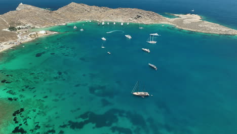 Birds-eye-view-above-a-secluded-cove-with-yachts-in-Paros,-Greece
