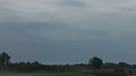 Timelapse-of-dark-clouds-above-a-forest-and-a-field