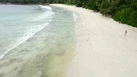 Mahe-Seychelles-Drone-Volador-Rápido-En-La-Playa-Sobre-La-Gente