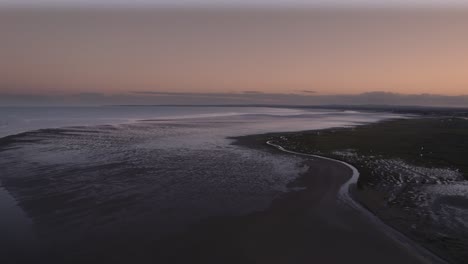 Drone-flight-over-Dundalk-Bay-during-sun-set,-flying-out-to-sea