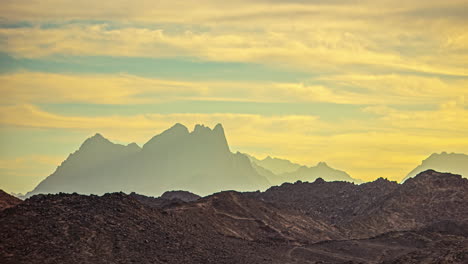 Zeitraffer-Von-Wolken,-Die-Sich-über-Wüstenlandschaft-Mit-Bergsilhouette-Im-Hintergrund-Bewegen