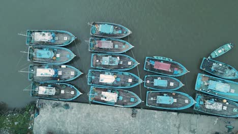 Ascending-top-down-shot-of-docking-old-fishing-boats-in-India