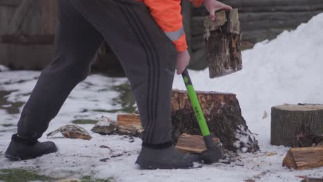 A-senior-man-in-his-sixties-is-chopping-wood-with-an-axe-during-the-European-winter-4K-Clip-1