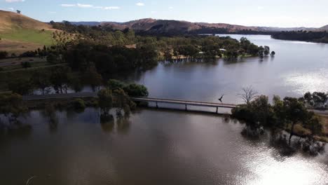 Circling-aerial-small-bridge-over-lake-Eildon,-Victoria-Australia