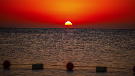 Time-lapse-shot-of-golden-sunset-behind-sea-at-horizon-in-the-evening,wide-shot