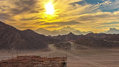 Goldene-Wolkenzeitraffer-In-ägypten-Bei-Sonnenuntergang-Mit-Bergen-Und-Fahrendem-Auto