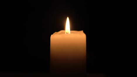 candle-burning-with-dark-background-clouse-up-footage