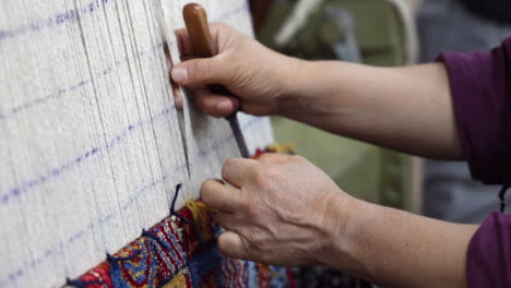 Woman's-hands-using-a-knife-to-cut-whilst-weaving-in-Turkey