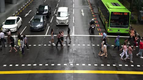 Street-scene-with-crowds-of-people-walking-across-an-intersection-in-Central-Business-District,-Robinson-Road-in-Singapore