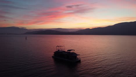 rotating-drone-shot-around-a-boat-on-kelowna-water-Okanogan-lake-sunset