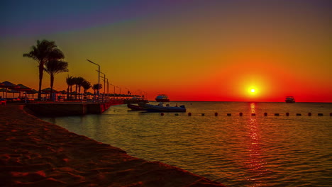 Brilliant-red-sunrise-over-the-Red-Sea-as-luxury-yachts-come-to-the-dock---time-lapse