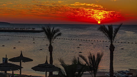 Wunderschöner-Zeitraffer-Des-Sonnenuntergangs-An-Einem-Strand-Mit-Palmen-Und-Terrassen