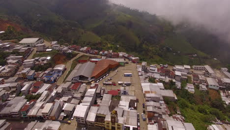 Drone-shot-over-Ecuadorian-town-edge-with-mountains-in-the-distance