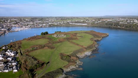 The-view-from-above-over-horseshoe-bend-of-river-Bandon-in-Kinsale,-Ireland-with-green-fields-of-a-peninsula-with-an-old-fort,-James-Fort