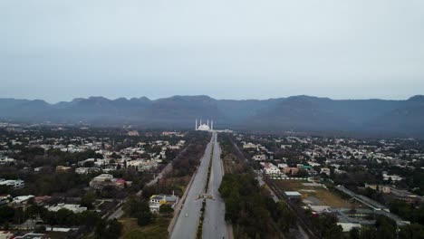 Toma-Aérea-De-La-Mezquita-Faisal-Islamabad-Desde-La-Distancia---Una-Vista-De-La-Ciudad-De-Islamabad-Desde-La-Autopista-Islamabad