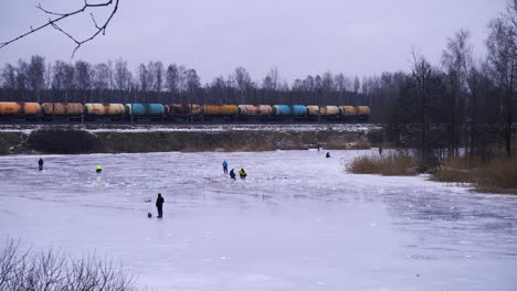 Along-the-lake-where-a-train-passes-by-ice-fishing